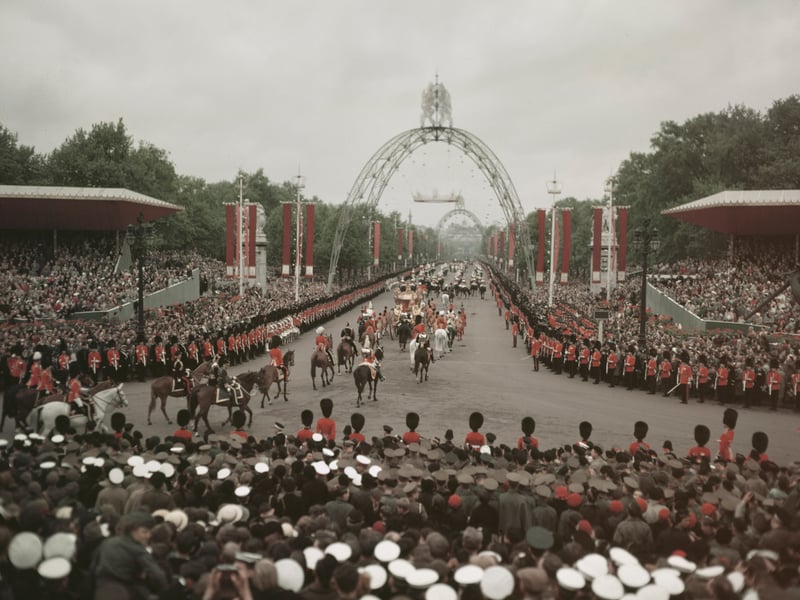 British sailors, soldiers and crowds line the route of Queen Elizabeth's coronation procession, the Mall, London, 2nd June, 1953. Coronation arches can be seen in the background