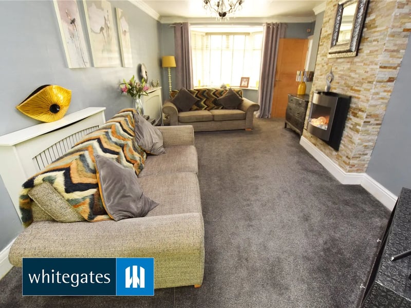 The room has a log burner and a bay window.