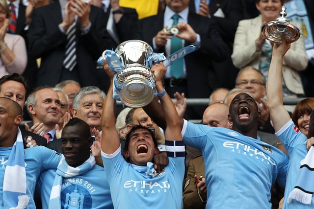 Manchester City's Argentinian footballer Carlos Tevez (C) celebrates with team-mates winning the FA Cup final football match between Manchester City and Stoke City at Wembley Stadium in London