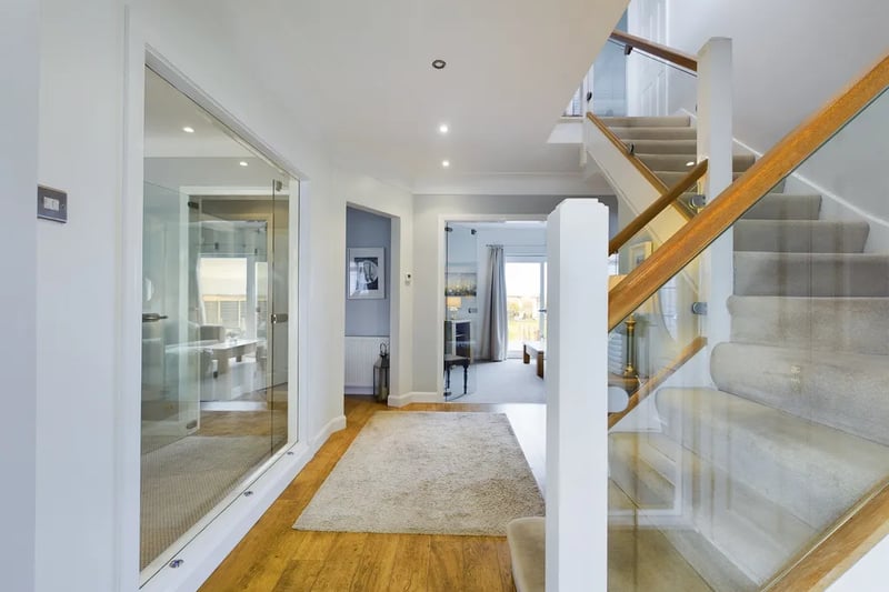The spacious main property sports a beautiful entrance hallway with glass doors and staircase.