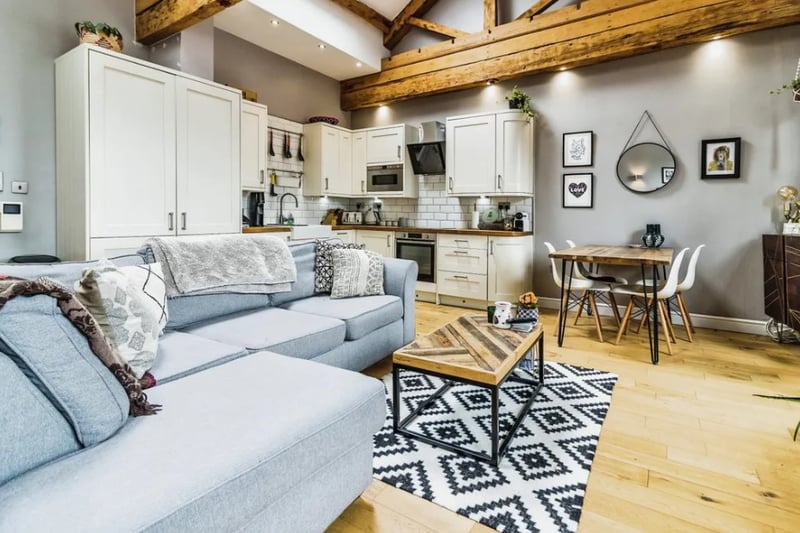 The open plan living room has lots of classic features like exposed wooden beams