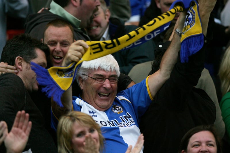 One fan holds his scarf high as he enjoys Bristol Rovers vs Lincoln City.