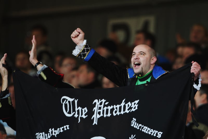 A Bristol Rovers fan cheers as he holds his flag up. 