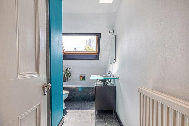 Tiled bathroom with white two piece suite, standalone wash hand basin and vanity unit and separate walk-in shower. 