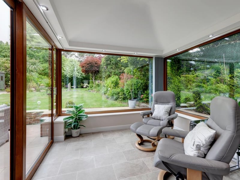 The garden room has large windows offering views into the backyard.