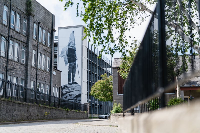 Another Spanish artist, Jofre Oliveras’ Aberdeen mural titled “The Man Who Owns The Stone” focuses on societal disconnection, meeting the theme of reconnection for Nuart 2022. Perhaps controversial for Scotland, a proud country, Oliveras thinks “nationalism obscures the vision” and that “identifying with national identity is defending the interests of the people who oppress us". Regardless, his Frederick Street mural featuring a man with his face covered by a flag is thought provoking political and continually relevant. 