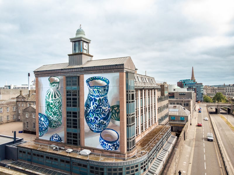 Manolo Mesa’s street art has been featured on walls around the world, from his home country of Spain to the likes of Poland, the US and even Algeria. After beginning his art career painting graffiti with his older brother, Francisco Mesa, in 2002, his works developed after studying at the University of Fine Arts in Seville. Mesa’s Aberdeen mural graces the walls of the Robert Gordon’s College Blackfriars Building and features ceramics. The artist uses his study of the objects to question the links between past and present, tradition and innovation, and abandonment and resistance. This work is on St Andrew Street, but can be spotted from Denburn Road.