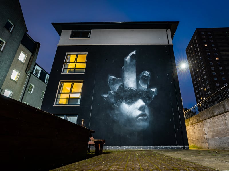 Another artist who made their Nuart debut in Aberdeen’s sister city Stavanger, Norwegian painter Henrik Uldalen took inspiration from the Granite City for his 2021 mural. Painted on the side of student accommodation Spring Gardens, his image of a black and white face with crystals bursting from above the eyes can be seen from Aberdeen’s Gerrard Street.