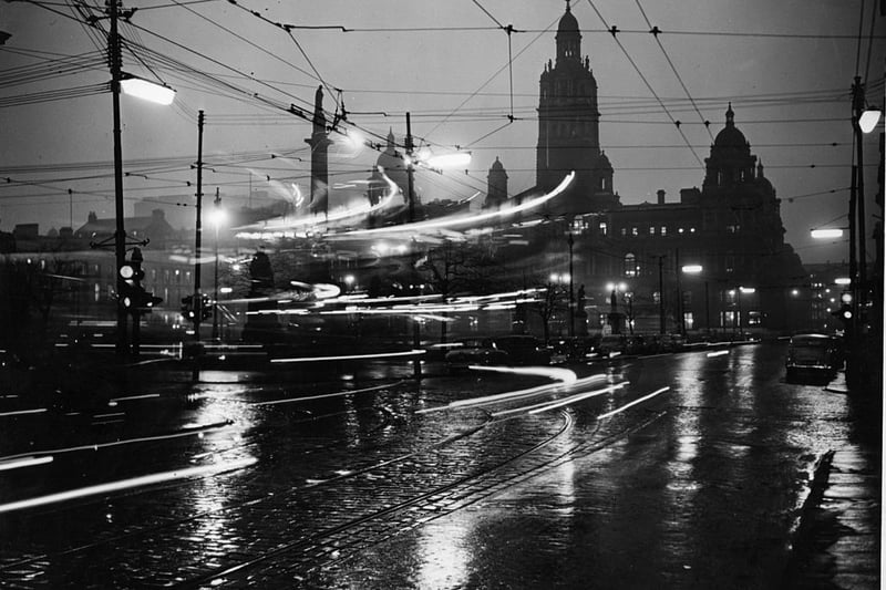 The lights of moving traffic streak past on a rainy night in Glasgow in 1955. 