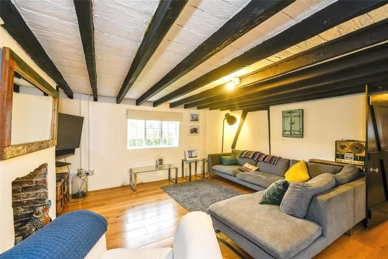 The interior of the well-presented property includes a spacious living room with original beams.