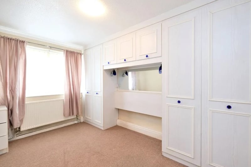 The bedroom is spacious with large built-in wardrobes