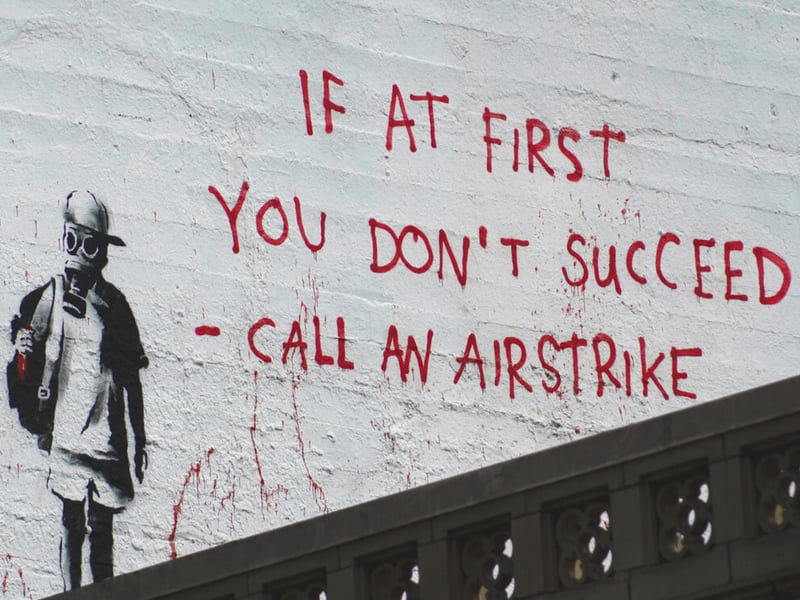 ‘If at First You Don’t Succeed - Call an Airstrike’ first appeared in San Francisco, California. The graffiti was created at a time when criticism towards the United States was increasing over their missile strike action in other countries. The Banksy Explained website calls it a “ statement about how America is perceived by the world as an airstrike-happy country.”