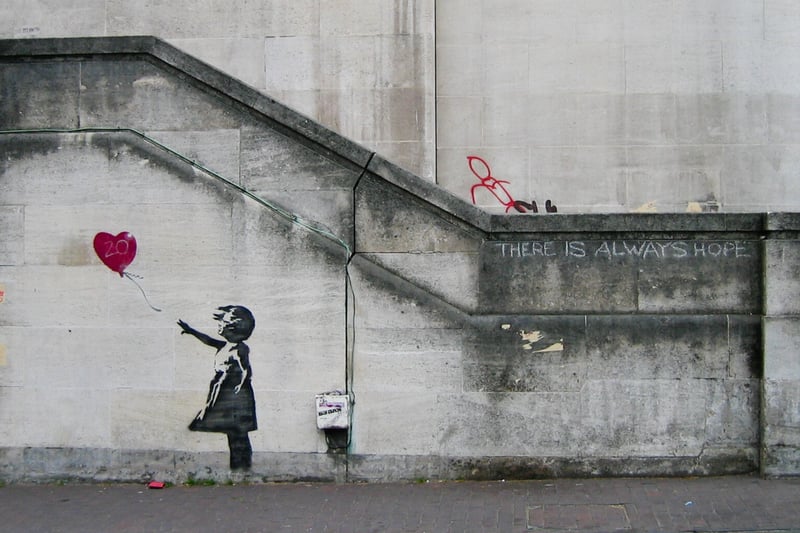‘Girl with Balloon’ was first unveiled in London’s South Bank area back in 2002. The art depicts a small girl attempting to grab a heart-shaped balloon which is being carried by the wind away from her. The image seemingly depicts despair but a short phrase written nearby reads: “There is always hope”.