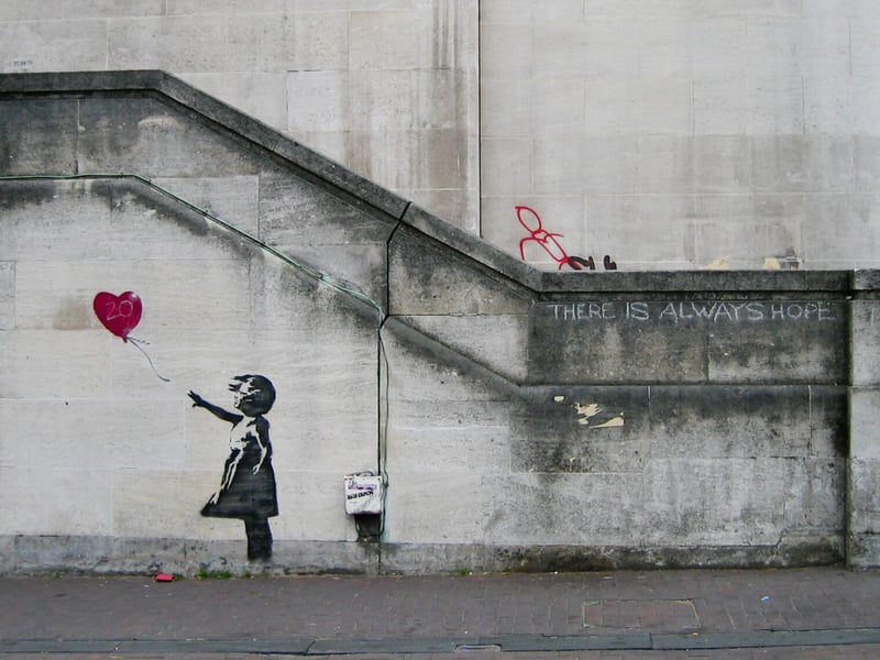 ‘Girl with Balloon’ was first unveiled in London’s South Bank area back in 2002. The art depicts a small girl attempting to grab a heart-shaped balloon which is being carried by the wind away from her. The image seemingly depicts despair but a short phrase written nearby reads: “There is always hope”.