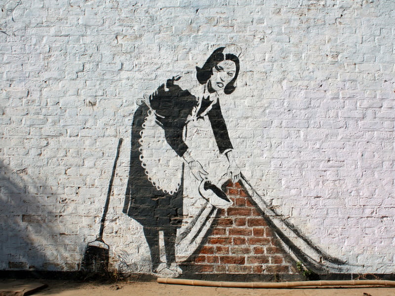 Banksy produced this piece at Chalk Farm in London. Reportedly, it is an homage to a cleaning lady named Leanne who took care of his room when he was in Los Angeles. Rather than draw the rich people that such workers serve, it serves to pay tribute to this woman and others like her who are likely to go unrecognised for their service.