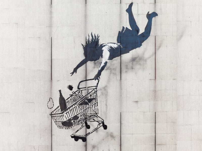 ‘Falling Shopper’ can be found in London’s Mayfair district. It is said to be one of the better preserved Banksy works as it is placed so high off the ground. It depicts a woman plummeting to her death as she desperately reaches out to her shopping trolley. It reminds us of the (perilous) dangers of consumerism.
