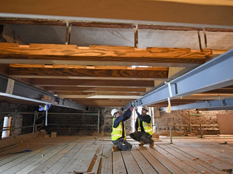 The original floor was suspended from beams above the book store by metal stirrups which survived the fire and are being retained in the restored building Restoration of Glasgow School.