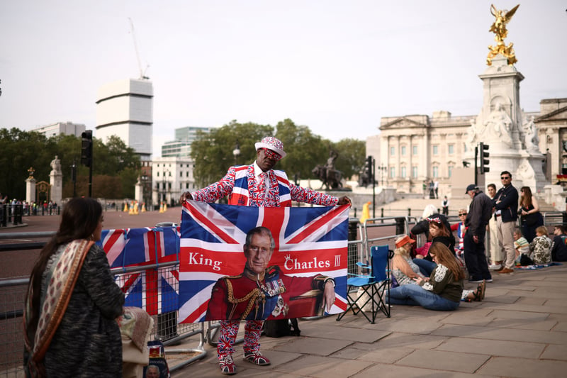 A royal super-fan poses at the Queen Victoria Memorial in front of Buckingham Palace prior to the King’s Birthday Parade. (Photo by HENRY NICHOLLS/AFP via Getty Images)