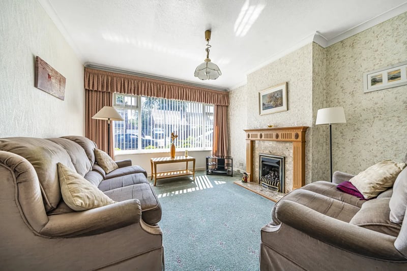 The cosy living room has a log burner and large windows.