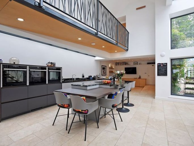 The kitchen is very modern and benefits from big, bright windows.