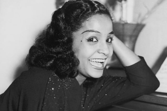 Just before her 20th birthday, Mona Baptiste boarded the HMT Empire Windrush, arriving in England on June 22 1948. She was one of just a few women on the ship, and travelled first class, along with other musicians including Lord Kitchener.  A few weeks after arriving, she appeared on the “BBC Light Programme” - a major radio station, helping to launch her career in the UK. She became a guest vocalist for some of the leading artists of the day. And she performed for elites at Qualingo’s restaurant, whose clientele included Princess Margaret.
She was largely popular from songs such as “Calypso Blues” and “There’s Something in the Air”.
She also acted in multiple musical films, including Dancing in the Sun.