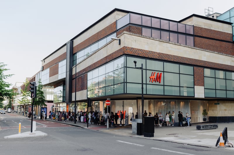 Shoppers queue round the newly-opened H&M to get in for opening