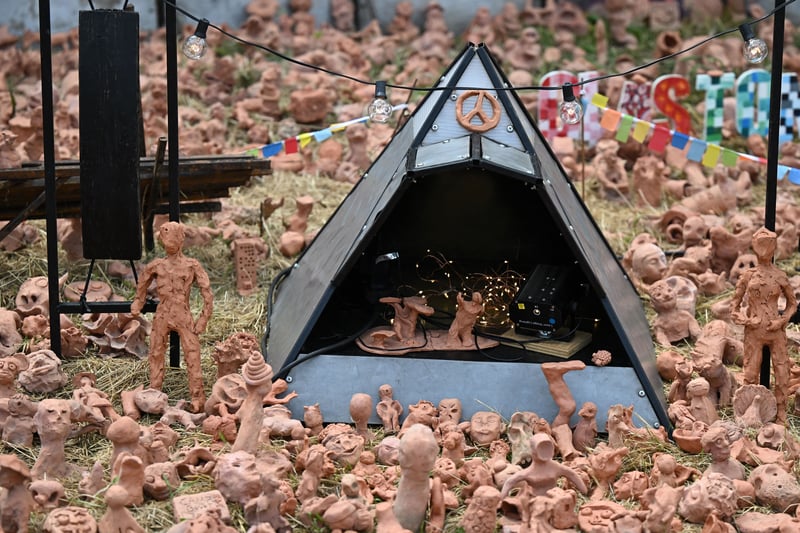 Clay models made by festivalgoers surround a miniature pyramid stage on day 3 of the Glastonbury festival. (Photo by Oli SCARFF / AFP) (Photo by OLI SCARFF/AFP via Getty Images)