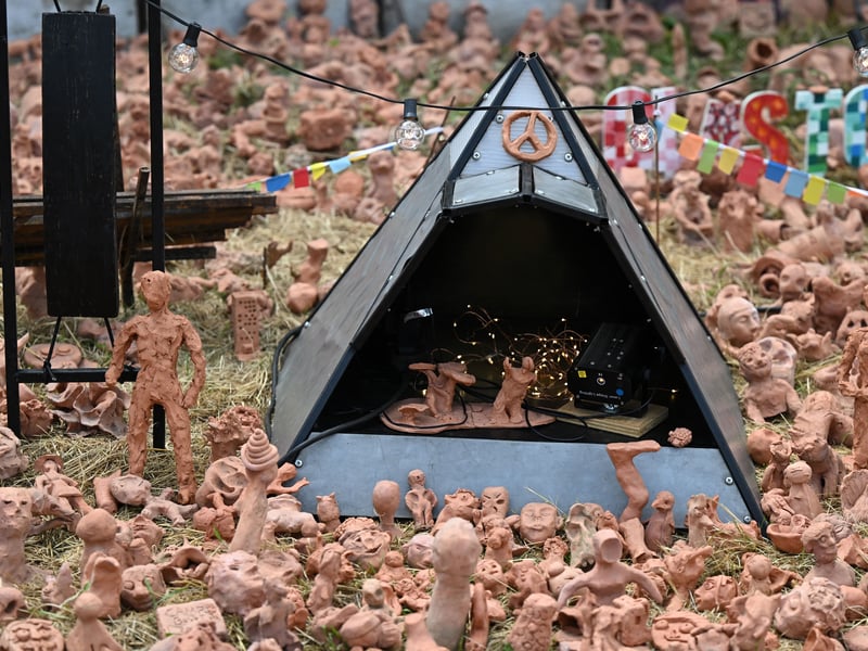 Clay models made by festivalgoers surround a miniature pyramid stage on day 3 of the Glastonbury festival. (Photo by Oli SCARFF / AFP) (Photo by OLI SCARFF/AFP via Getty Images)