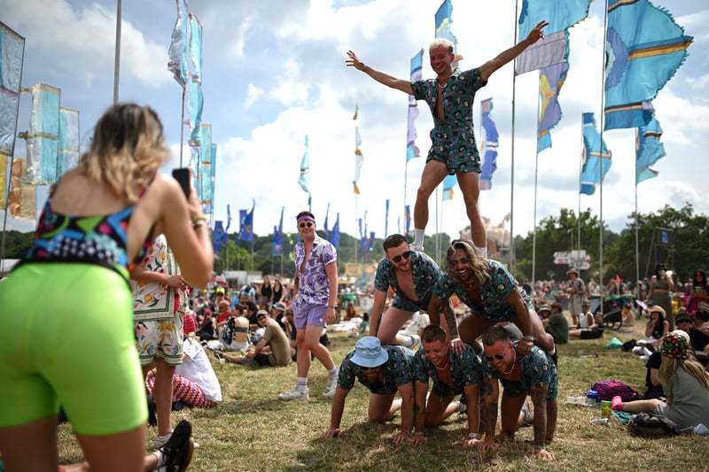 Festivalgoers build a human pyramid on day 3 of the Glastonbury festival in the village of Pilton in Somerset. (Photo by OLI SCARFF/AFP via Getty Images)