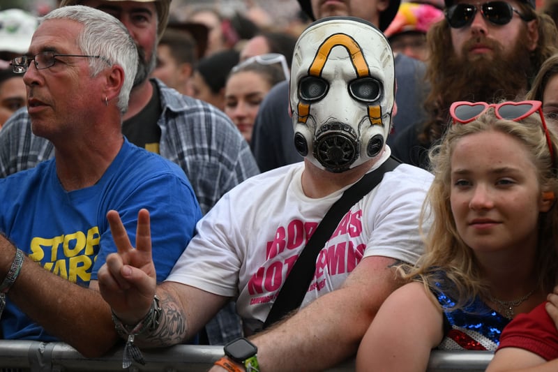 Festivalgoers wait to hear bands perform on the Pyramid Stage on day 3 of the Glastonbury festival. (Photo by OLI SCARFF/AFP via Getty Images)