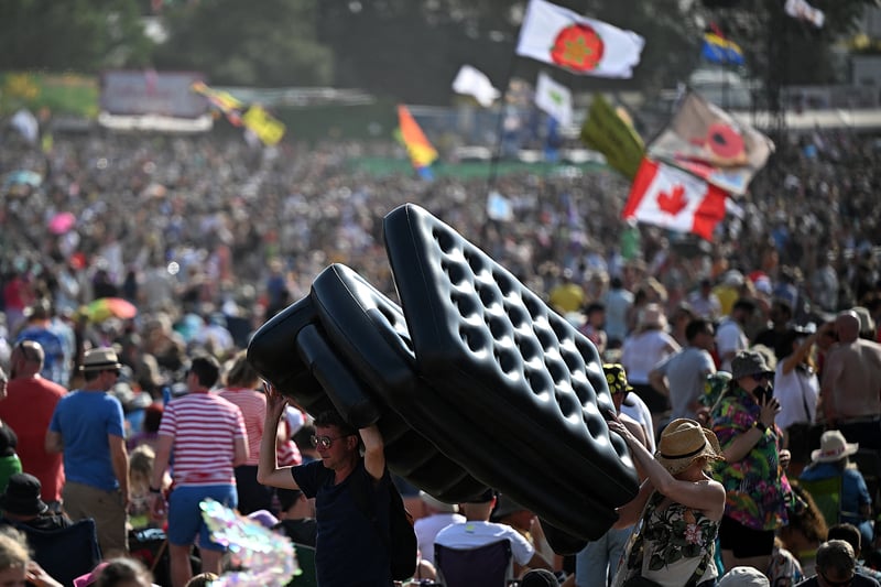 Festivalgoers carry an inflatable sofa on day 3 of the Glastonbury festival. (Photo by OLI SCARFF/AFP via Getty Images)
