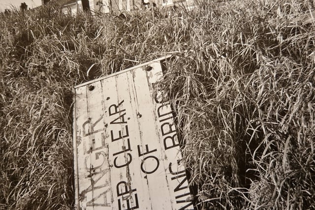 A discarded sign on the banks of the canal.