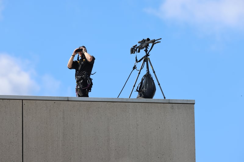 A police marksman keeps watch on the rooftop of the Scottish Parliament ahead of the service. 