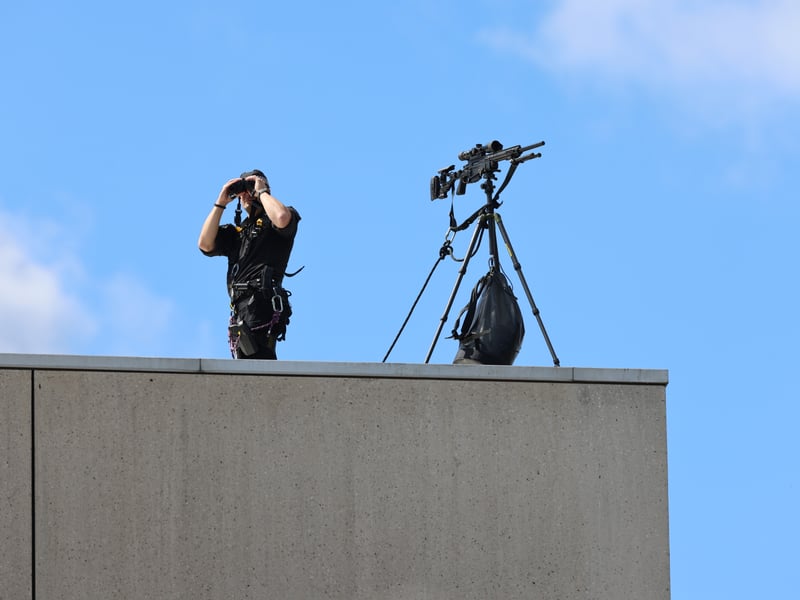 A police marksman keeps watch on the rooftop of the Scottish Parliament ahead of the service. 