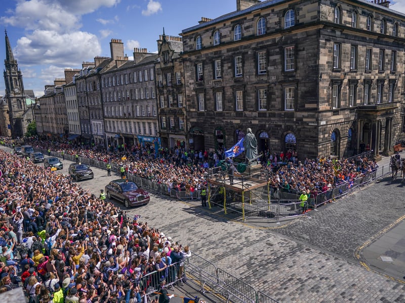 King Charles III And Queen Camilla move down the Royal Mile. 
