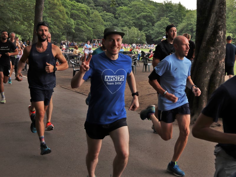 A runner makes a peace sign as he jogs past
