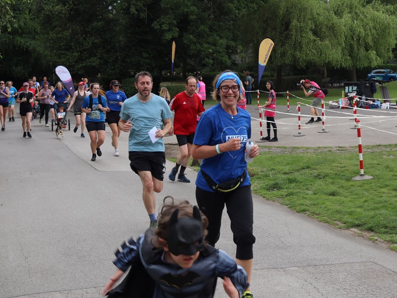 A smiling runner jogs along side Batman