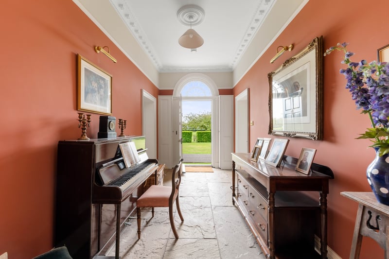 A room with a beautiful grand piano leads out to property’s grounds 