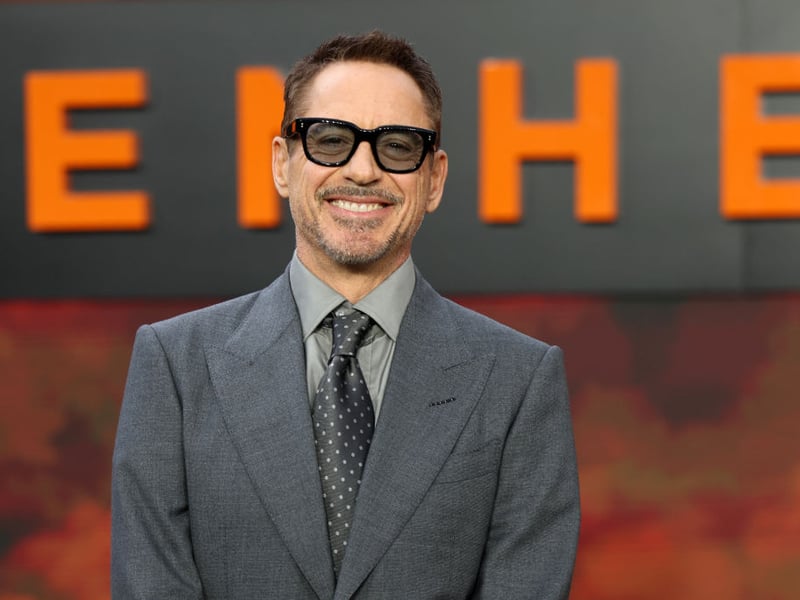 Robert Downey Jr. poses for photos on the red carpet at the Oppenheimer premiere.