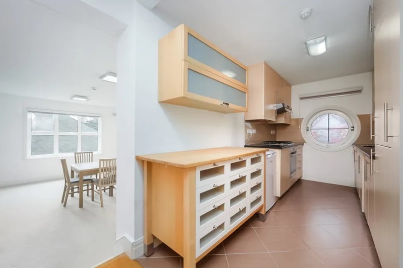 A small kitchen leads off from the living space and features lots of storage (Credit: Alexanders Lettings and Alexander Lets)