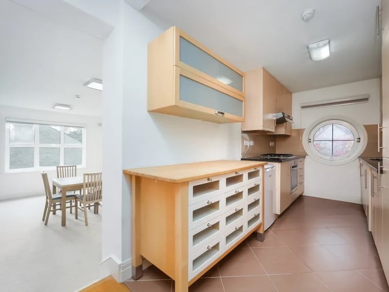 A small kitchen leads off from the living space and features lots of storage (Credit: Alexanders Lettings and Alexander Lets)