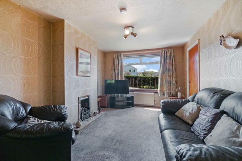 The living room looks out onto Avonbrae Crescent and front garden, with a feature fireplace too.