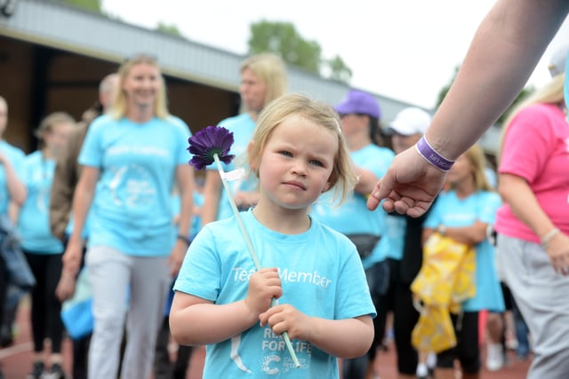 Young girl shows her support with a purple flower at the event