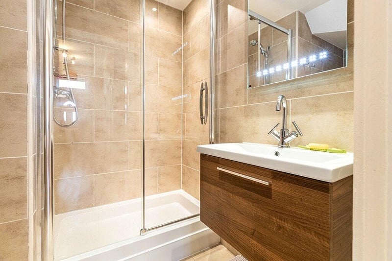 Three-piece shower-room comprising WC, wash hand basin with vanity storage, and generous walk-in shower, all complemented with quality wall and floor tiling, together with under floor heating. 