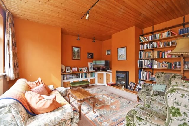 Warm, cosy lounge with embedded bookshelves and fireplace.