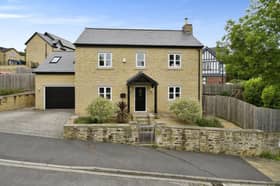The stone-built house has a stylish exterior, along with a garage and driveway with space for four cars.
