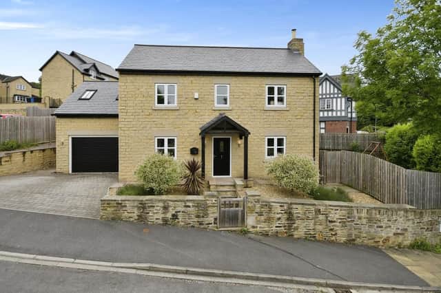 The stone-built house has a stylish exterior, along with a garage and driveway with space for four cars.