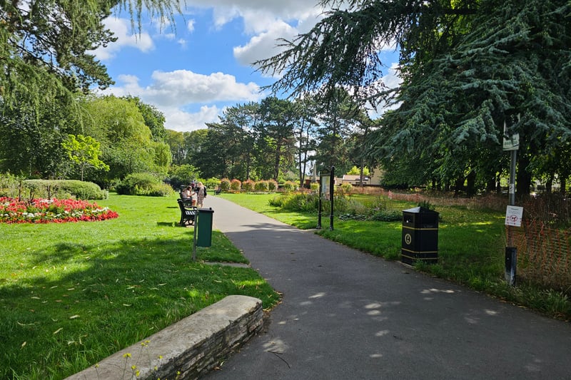 The park is overall flat and has multiple well-kept concrete paths. The paths are also surrounded by beautiful flowers and greenery.
