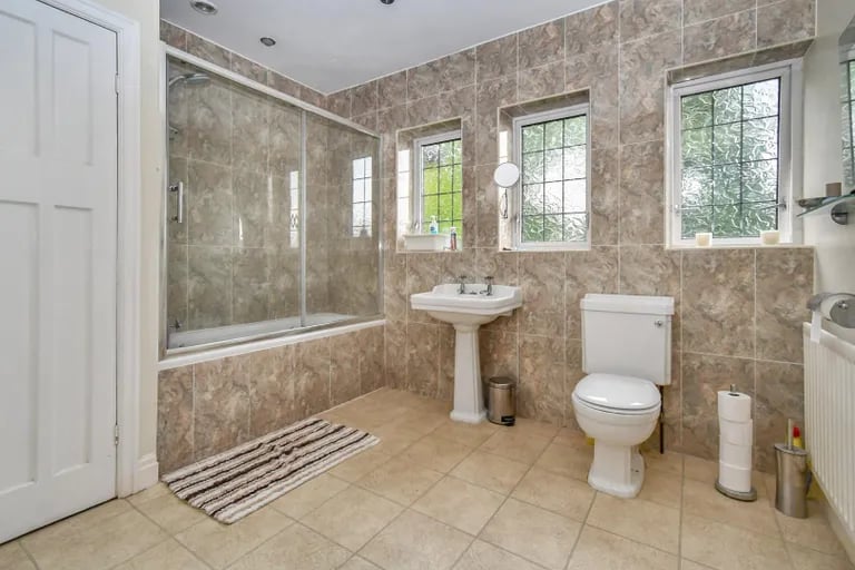A large family bathroom with a bathtub and shower.