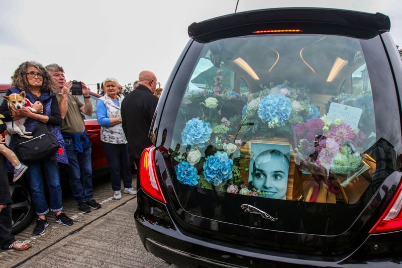 A photograph taken on August 8, 2023 shows the coffin and a picture of late Irish singer Sinead O'Connor, in the hearse during her funeral procession outside her former home in Bray, eastern Ireland, ahead of her funeral on August 8, 2023. A funeral service for Sinead O'Connor, the outspoken singer who rose to international fame in the 1990s, is to be held on Tuesday in the Irish seaside town of Bray.(Photo by PAUL FAITH/AFP via Getty Images)